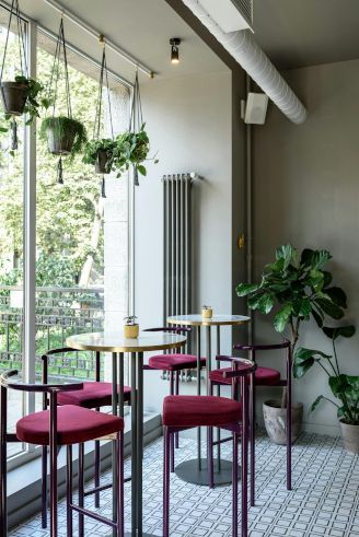 A room with tables and chairs in front of a large window.