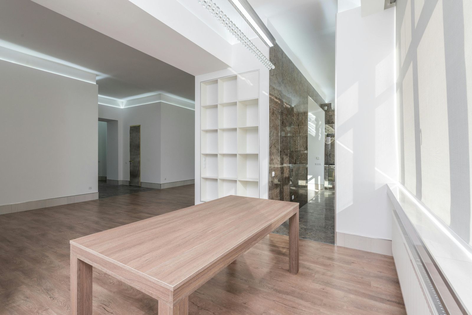 There is a wooden table in the middle of the room.