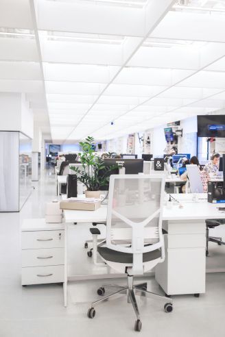 A blurred image of an office with a lot of desks and chairs.