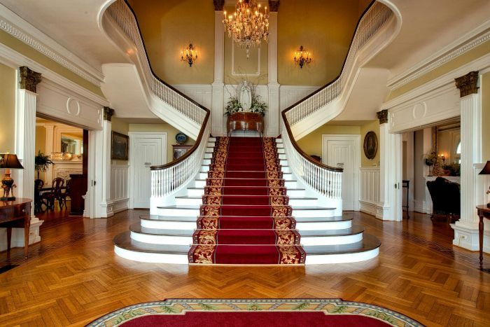 A large staircase with a red carpet and a chandelier