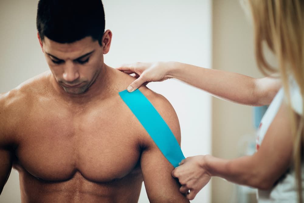 Physiotherapist Applying Kinesio Tape to Patient's Shoulder - Your Sports Physio in Bundaberg, QLD