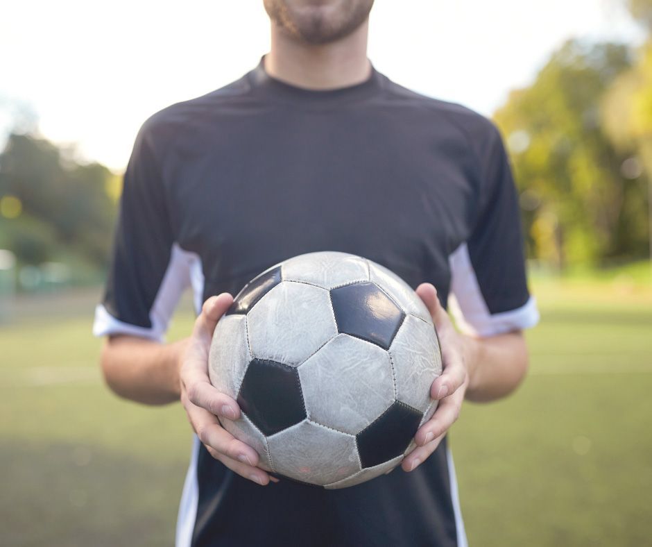 Man athlete holding a soccer ball - Your Sports Physio in Bundaberg, QLD