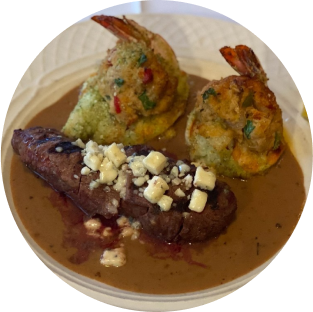 A close up of a plate of food with meat and shrimp