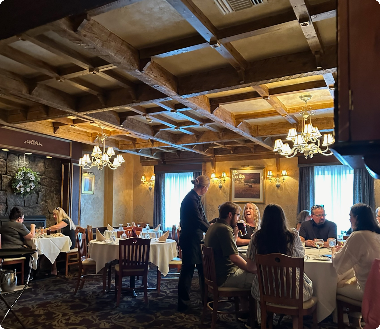 A group of people are sitting at tables in a restaurant