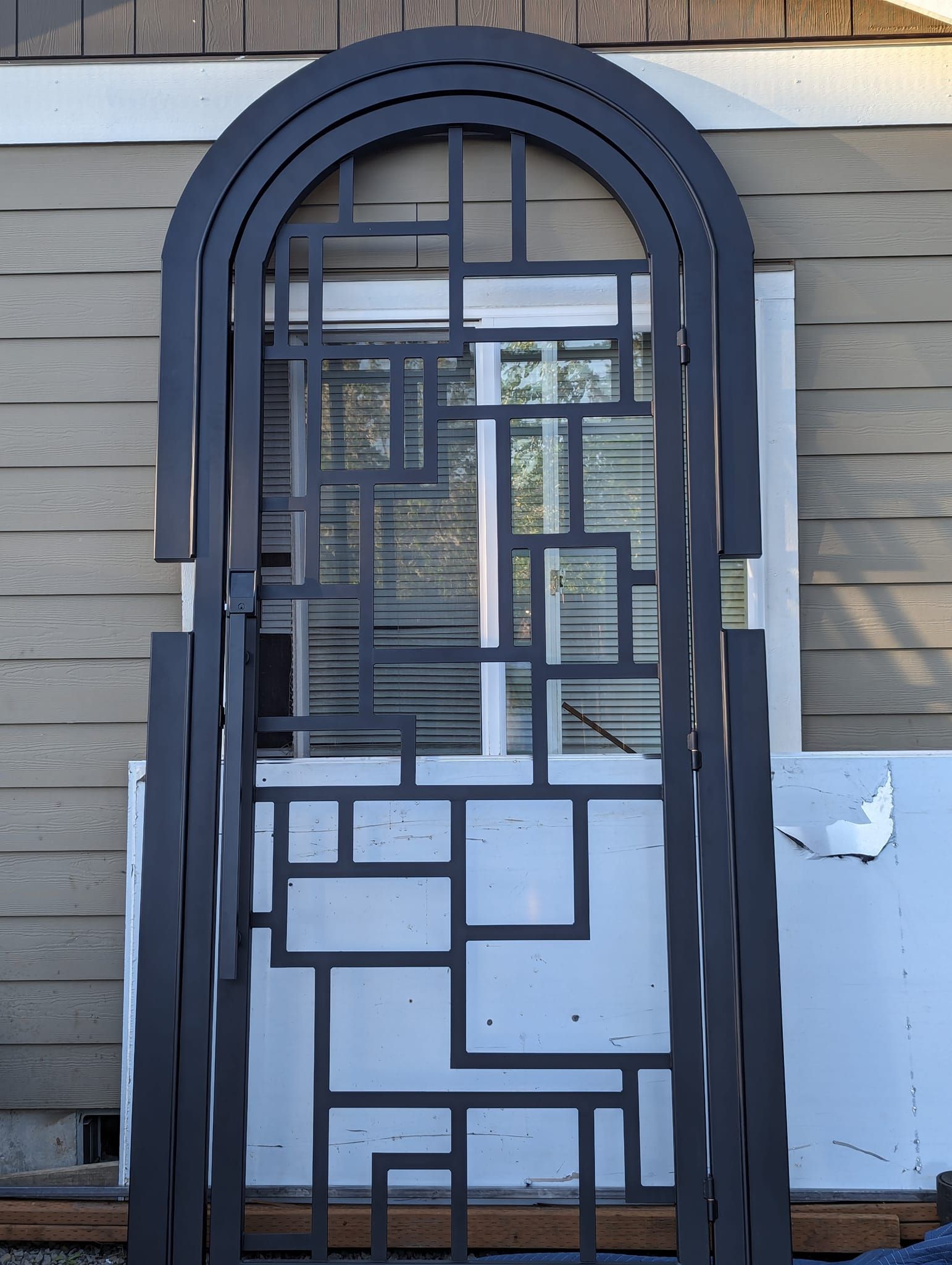 A wrought iron gate is sitting in front of a house