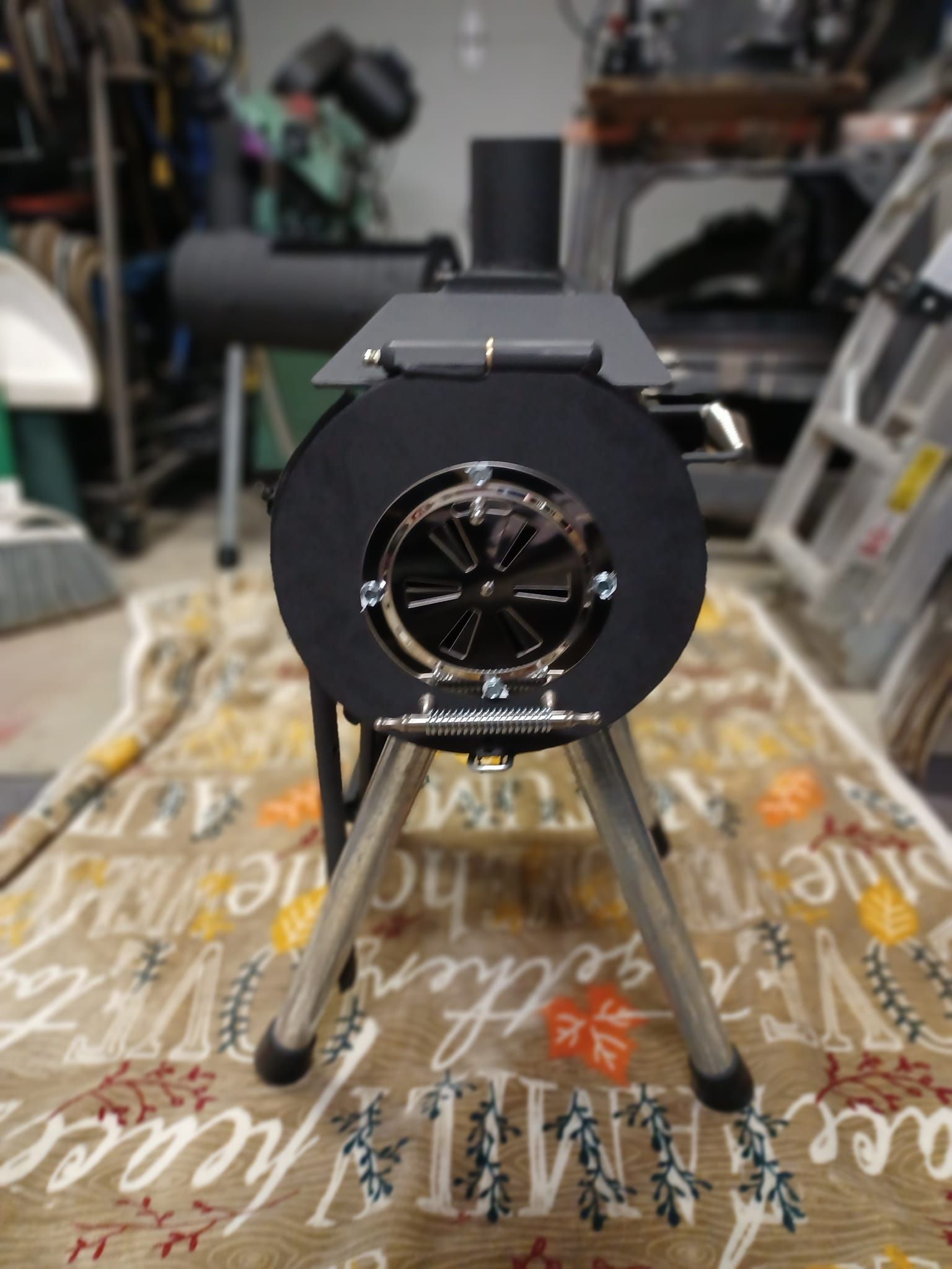 A small black stove is sitting on a rug in a garage.