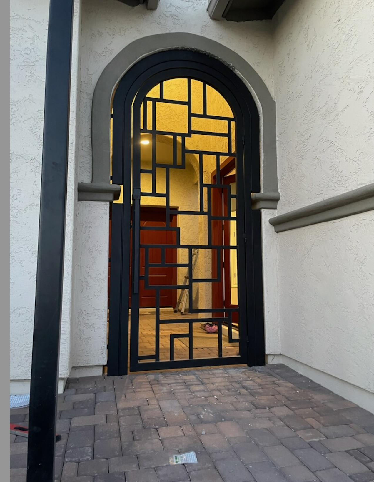 A piece of metal is sitting on the ground in front of a wooden fence.