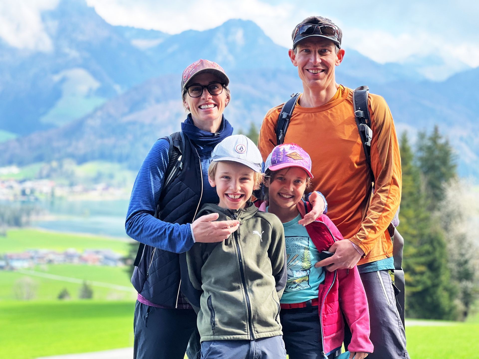 A family is posing for a picture in front of a mountain.