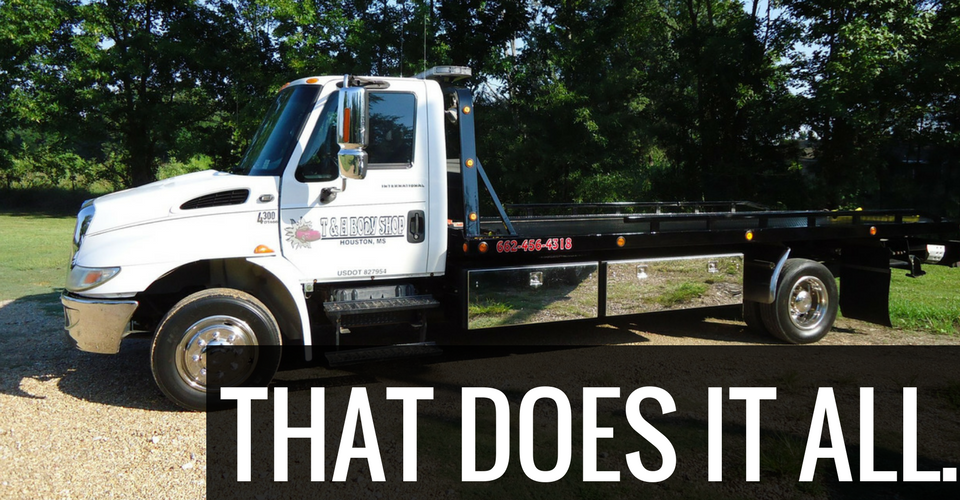 White tow truck on grass with the text,