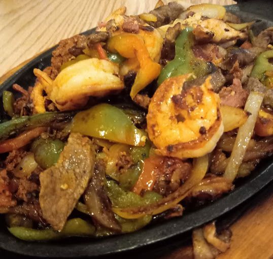 A plate of food with shrimp and vegetables on a table