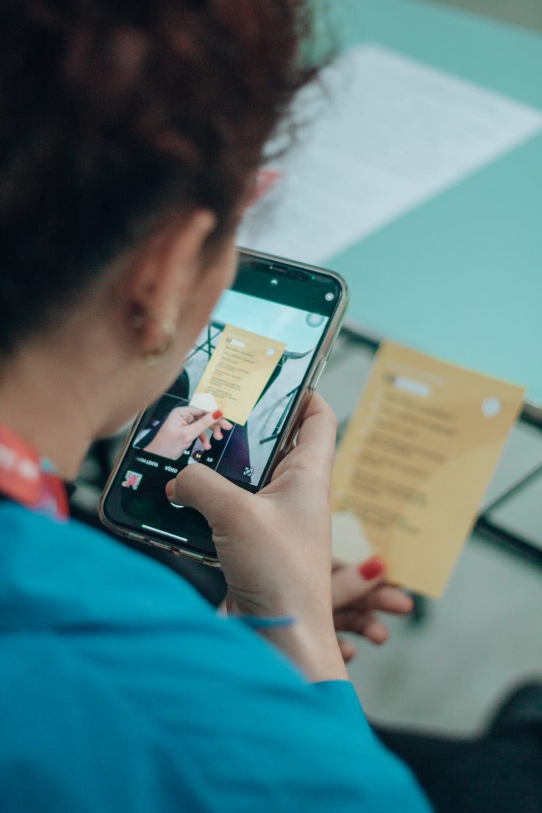 Uma mulher está tirando uma foto de um pedaço de papel com seu telefone.