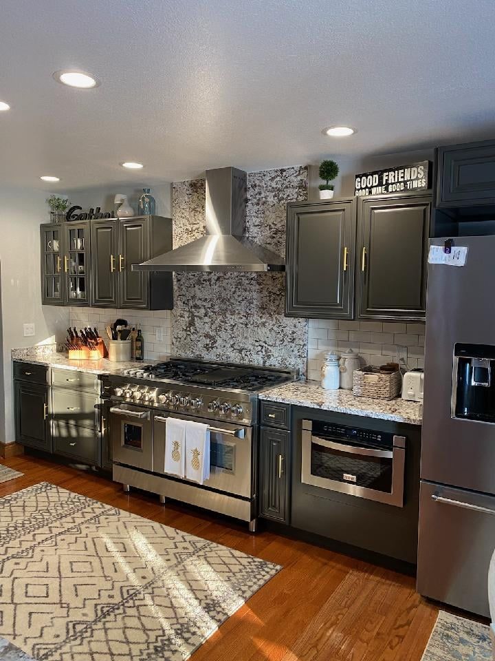 A kitchen with stainless steel appliances and black cabinets- Luther Falls Kitchen & Bath - Champaign, IL