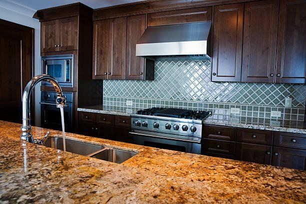 A kitchen with granite counter tops , stainless steel appliances , and wooden cabinets - Luther Falls Kitchen & Bath - Champaign, IL