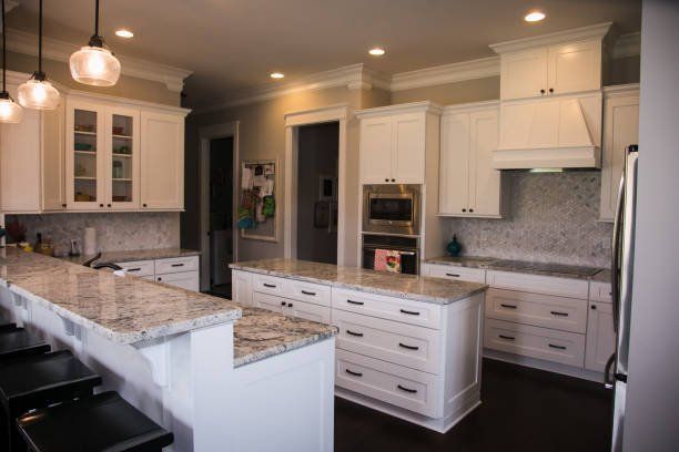 A kitchen with white cabinets and granite counter tops - Luther Falls Kitchen & Bath - Champaign, IL