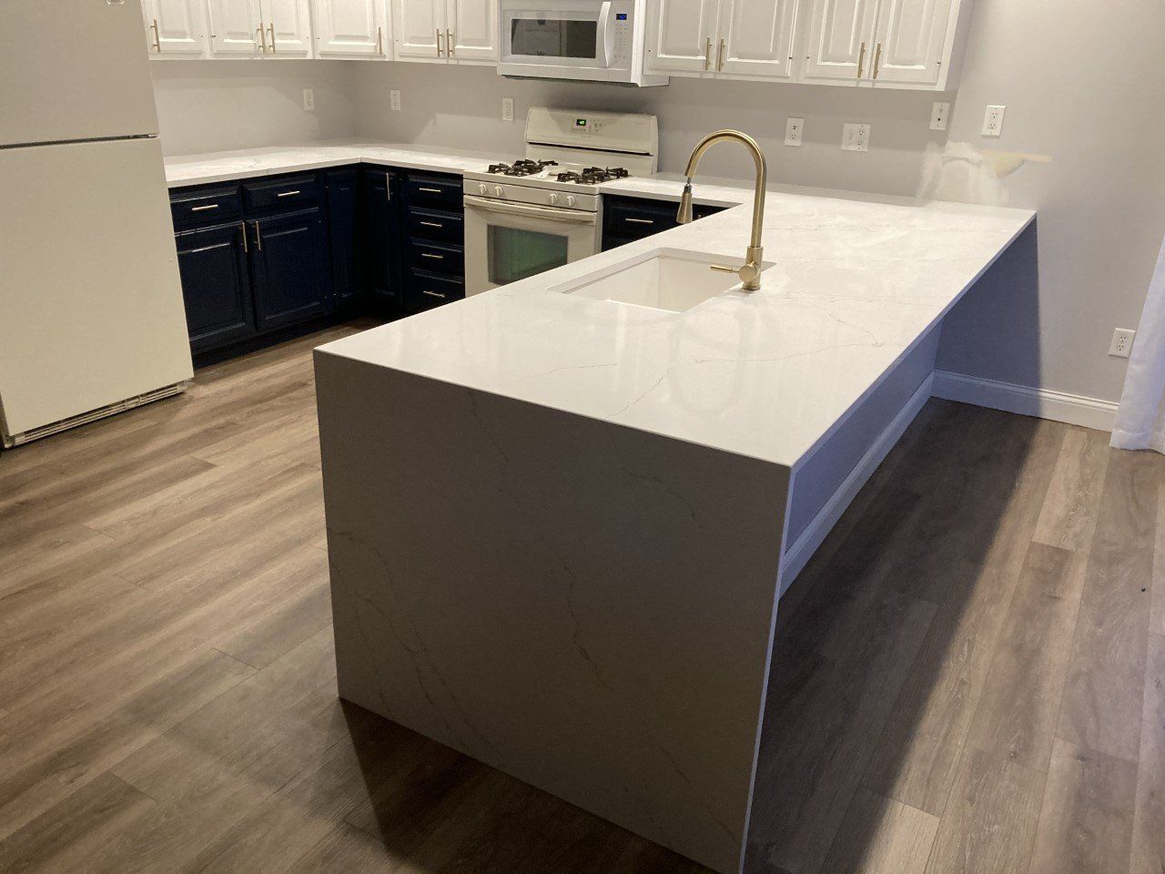 A kitchen with a large island in the middle of it - Luther Falls Kitchen & Bath - Champaign, IL