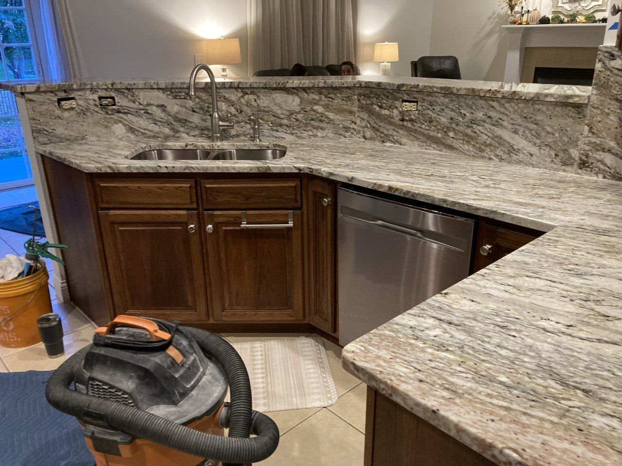 A vacuum cleaner is sitting on the floor in a kitchen next to a sink - Luther Falls Kitchen & Bath - Champaign, IL