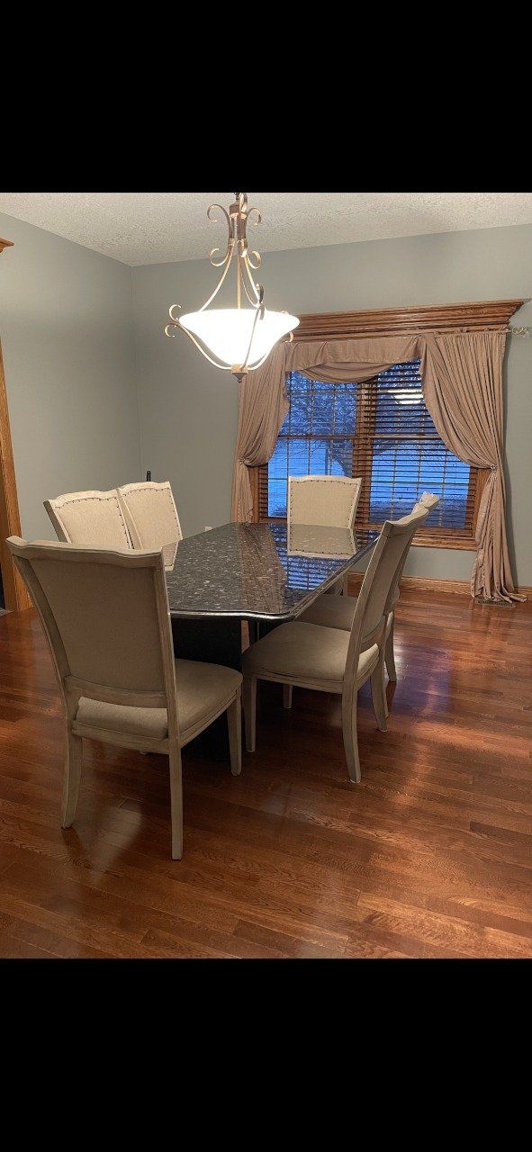 A dining room with a table and chairs in front of a window - Luther Falls Kitchen & Bath - Champaign, IL