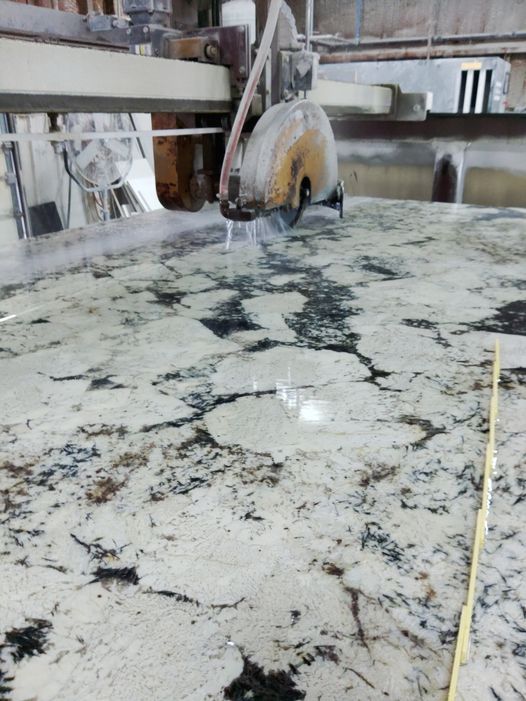 A circular saw is cutting a granite counter top - Luther Falls Kitchen & Bath - Champaign, IL
