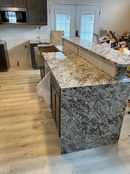 A kitchen with granite counter tops and a sink - Luther Falls Kitchen & Bath - Champaign, IL
