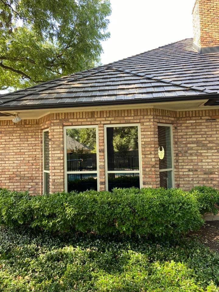 A brick house with a slate roof and a lot of windows