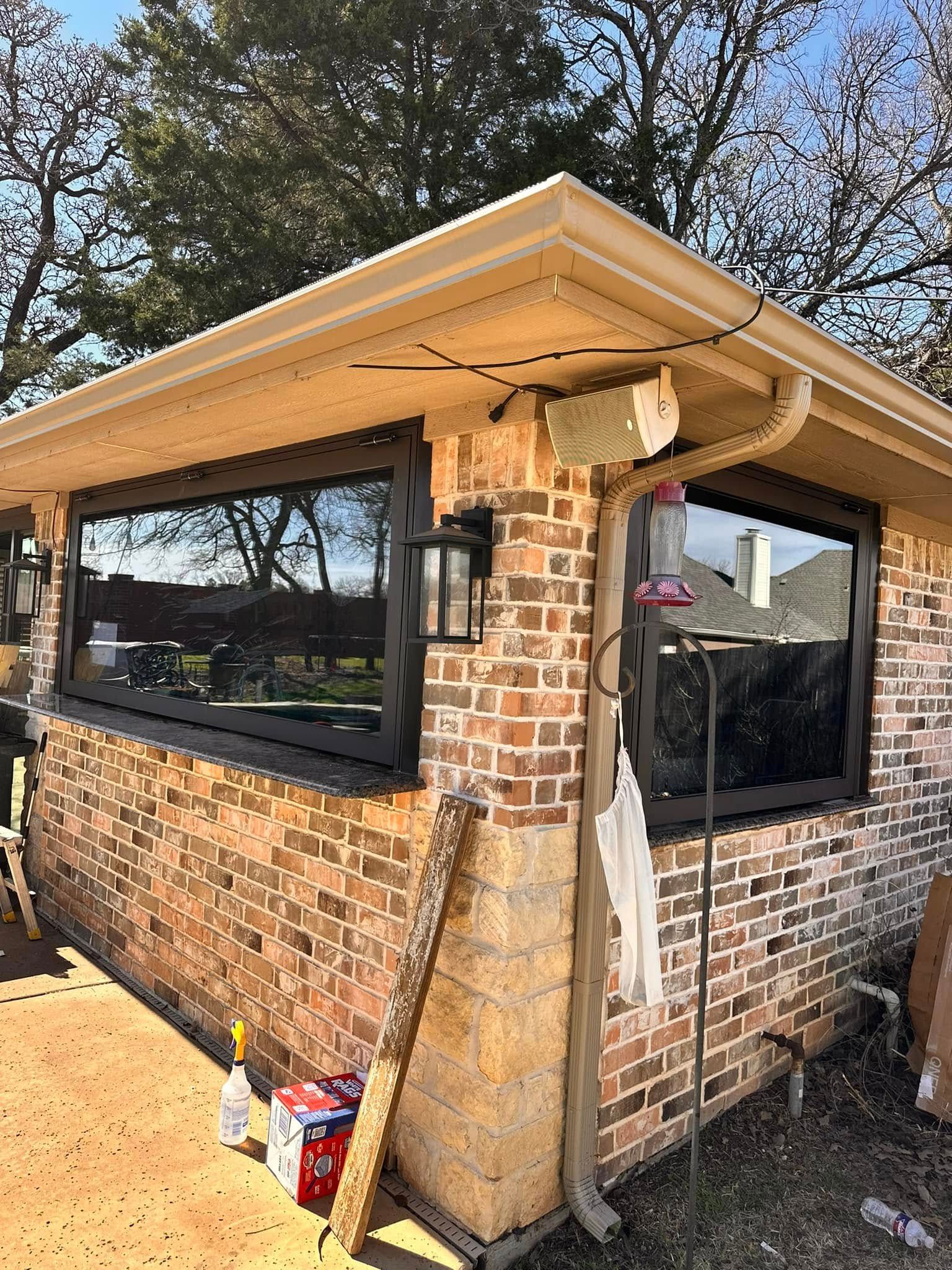 A brick house with a lot of windows and a gutter.
