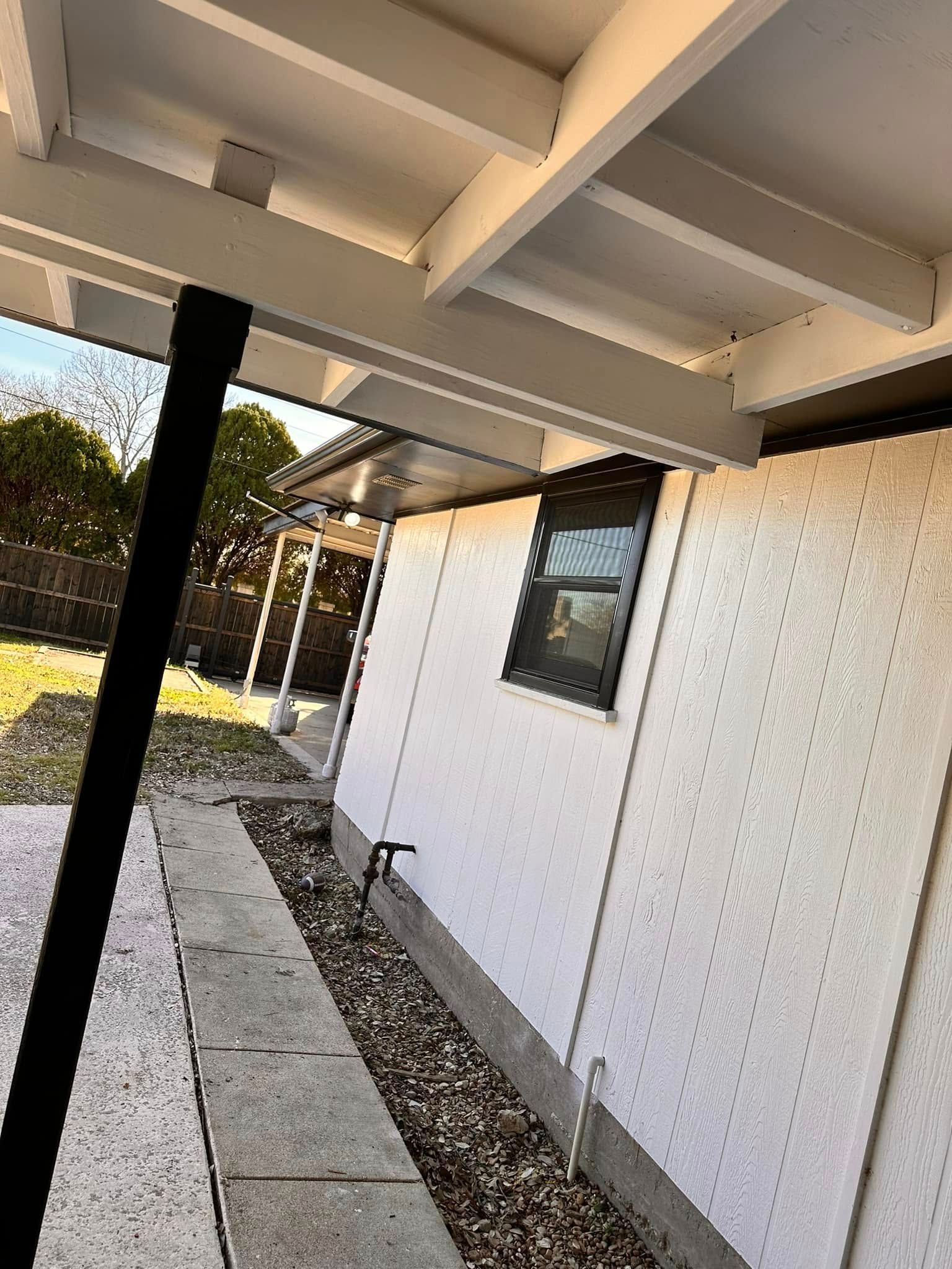 A white house with a covered porch and a window.
