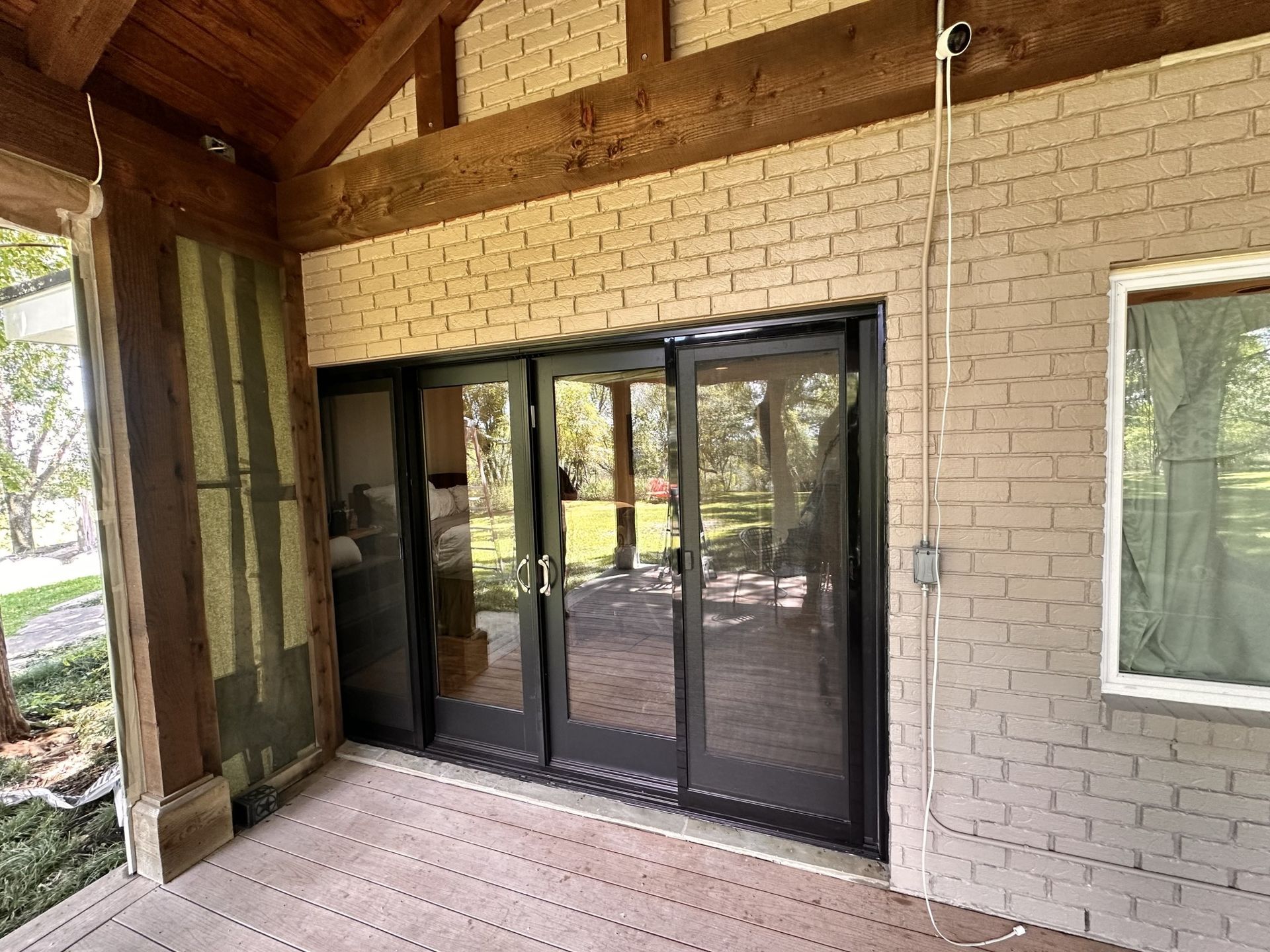 A porch with sliding glass doors and a brick wall.