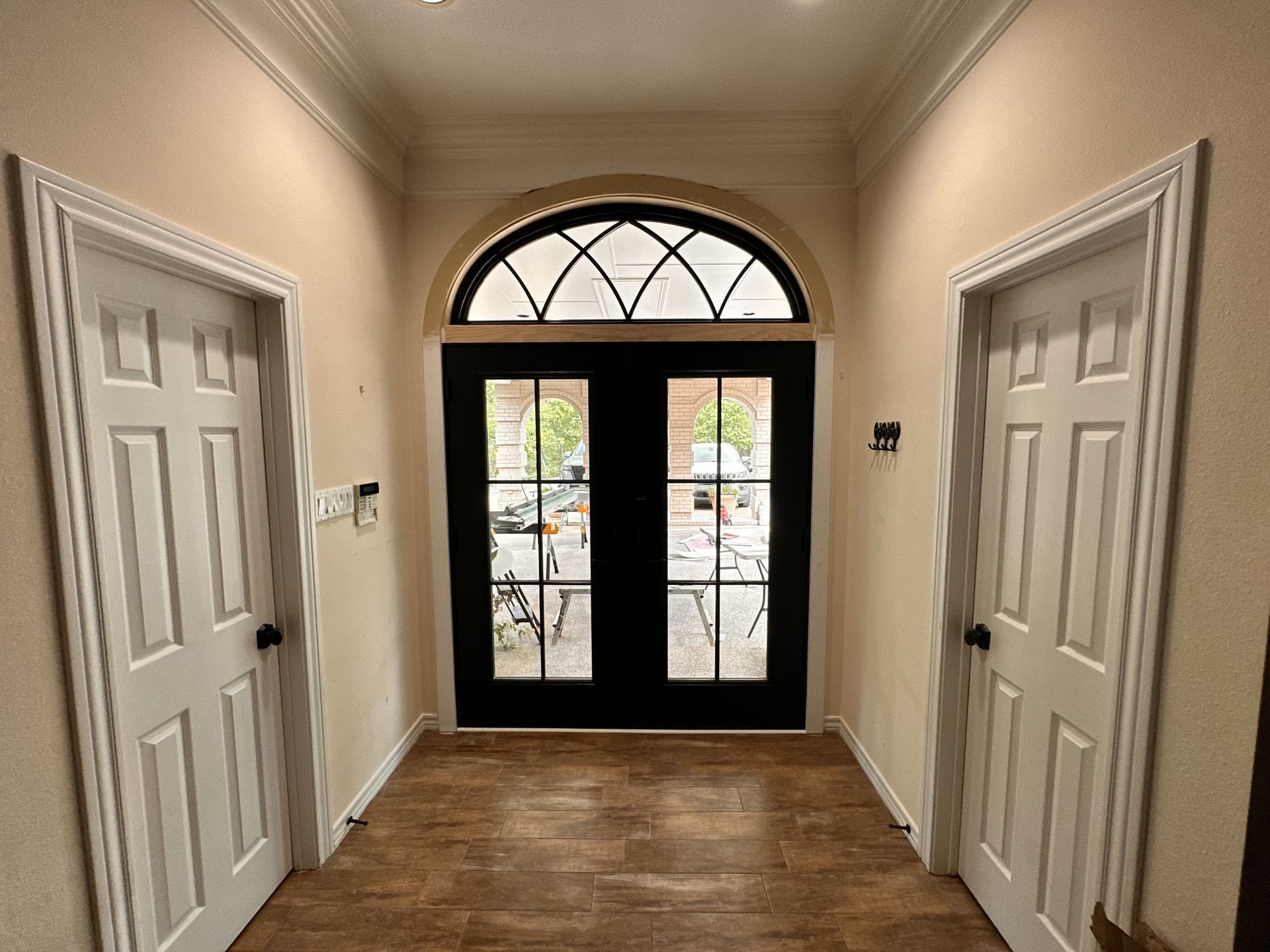 A hallway with two doors and a black door in a house.