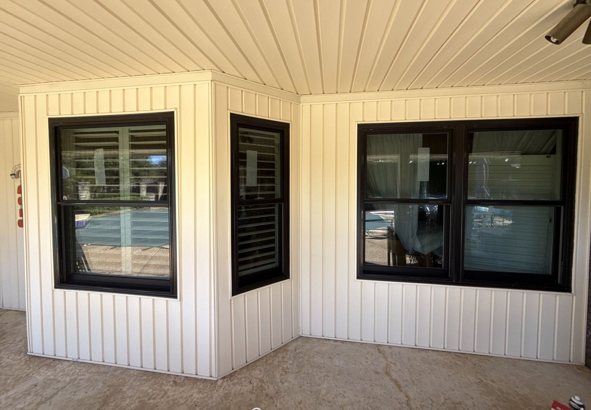 A white house with black windows and a ceiling fan