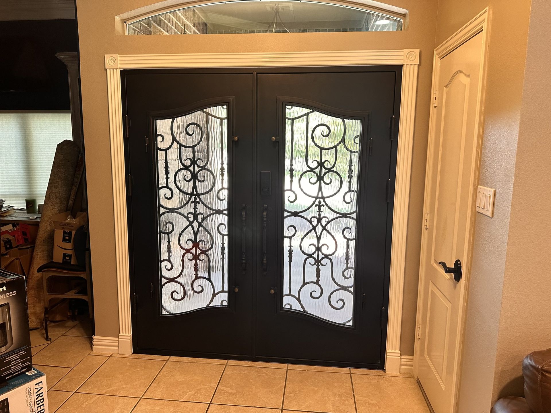 A pair of black double doors with stained glass in a living room.