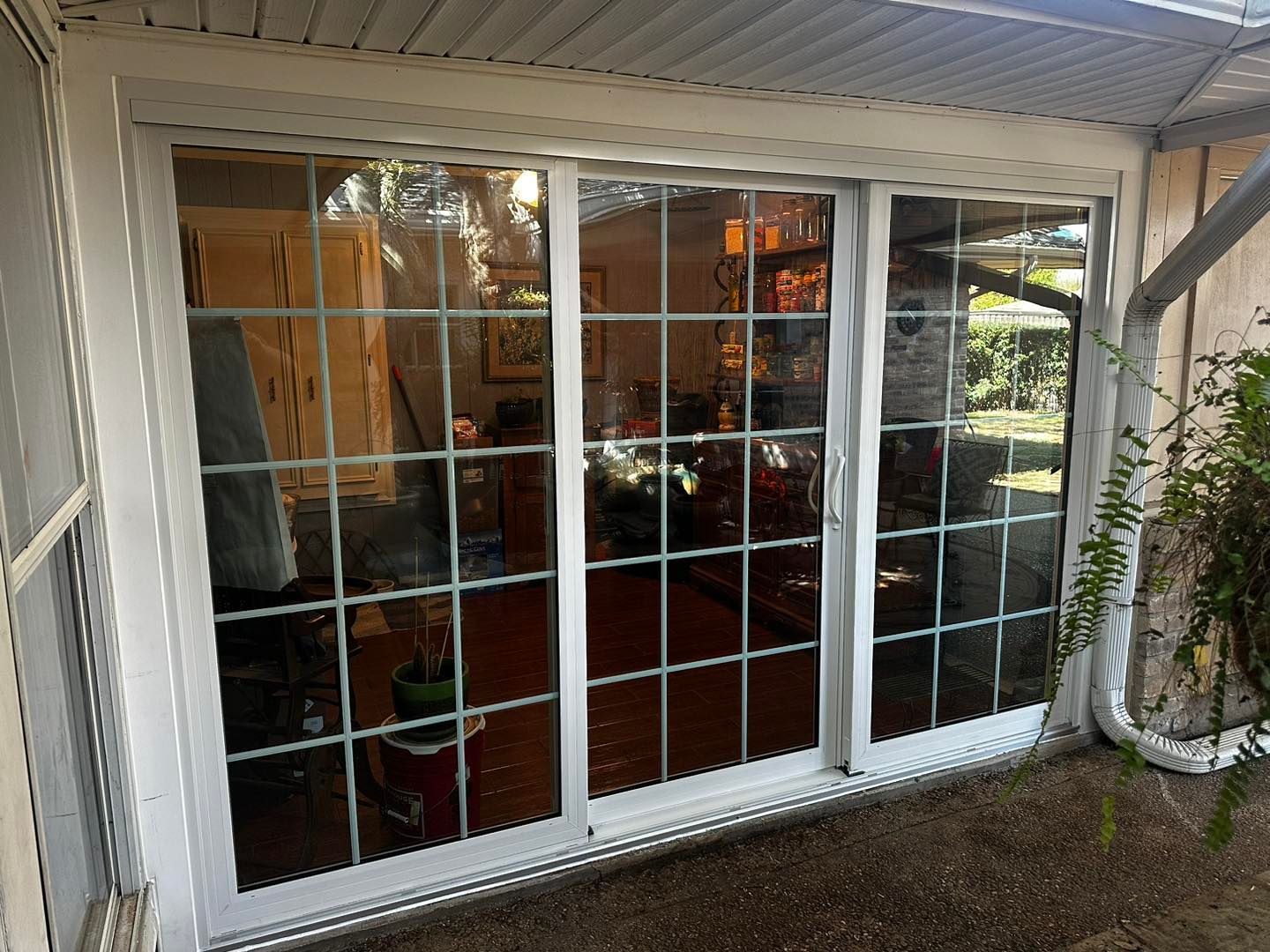 A white sliding glass door is open to a living room.