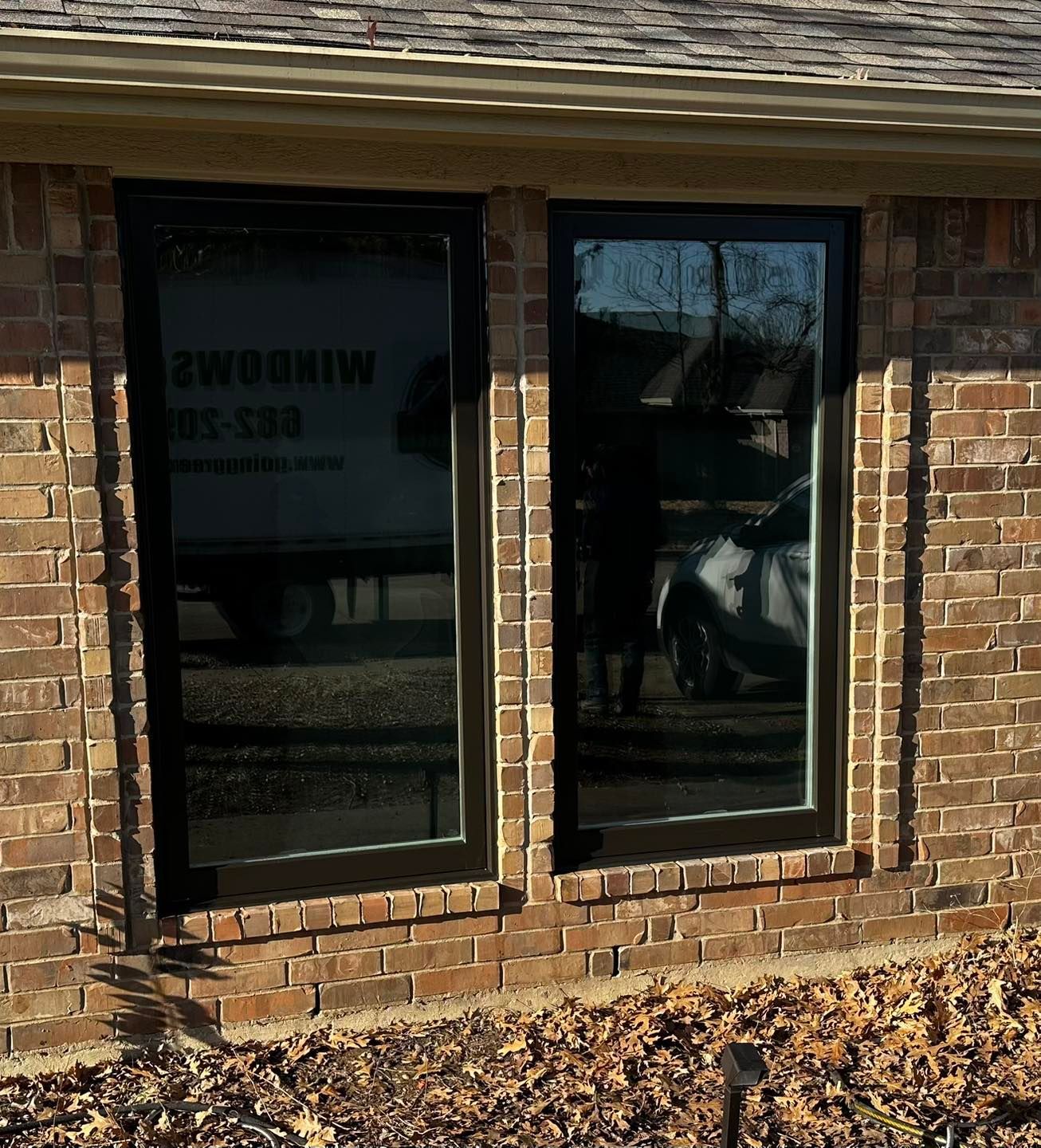 A brick building with two windows and a sign that says winddrive
