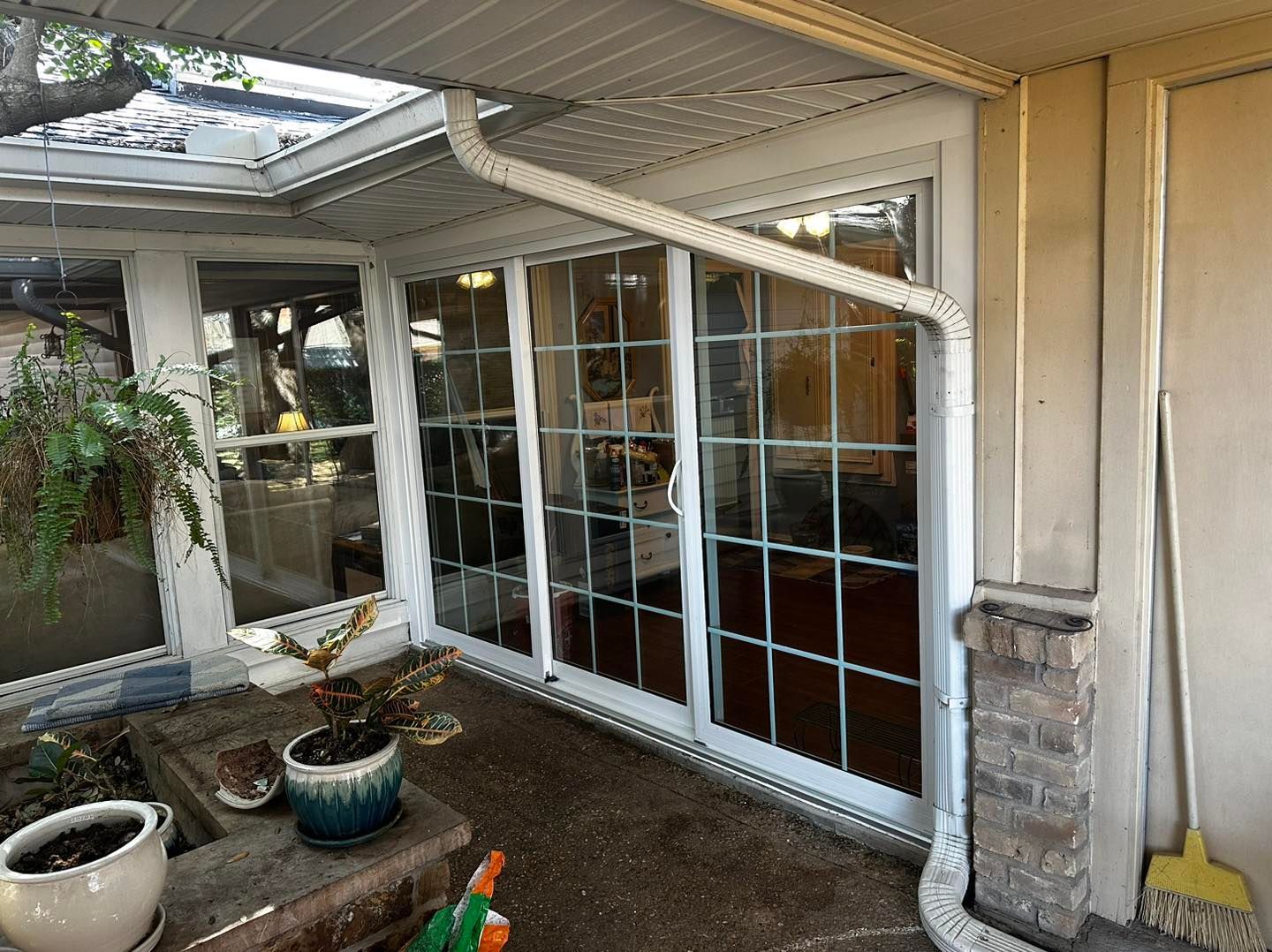 A patio with sliding glass doors and a broom.