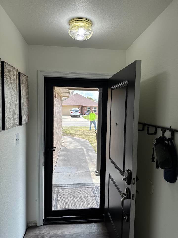 A hallway with a door open and a light on the ceiling.