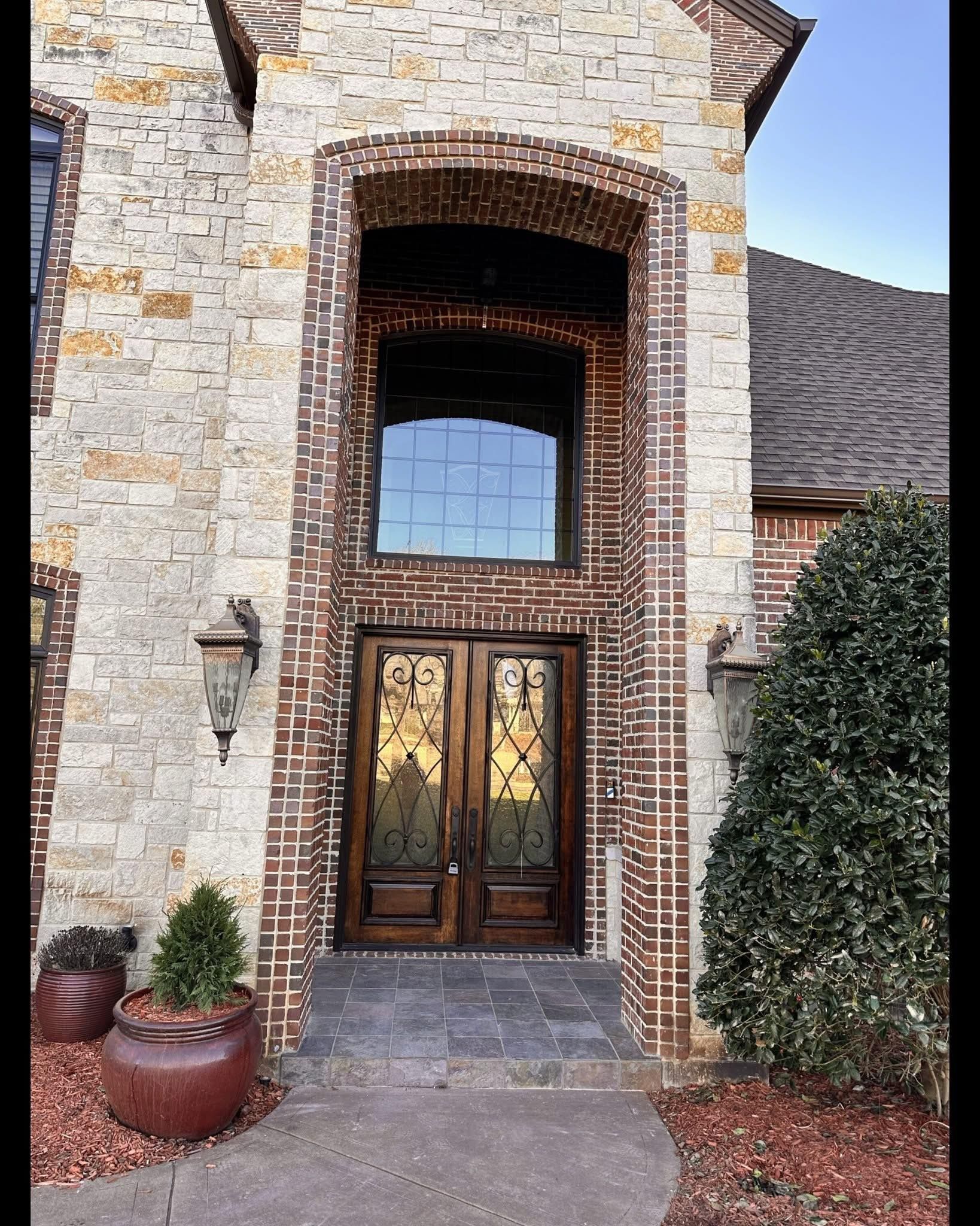 A large brick building with a double door and a large window.