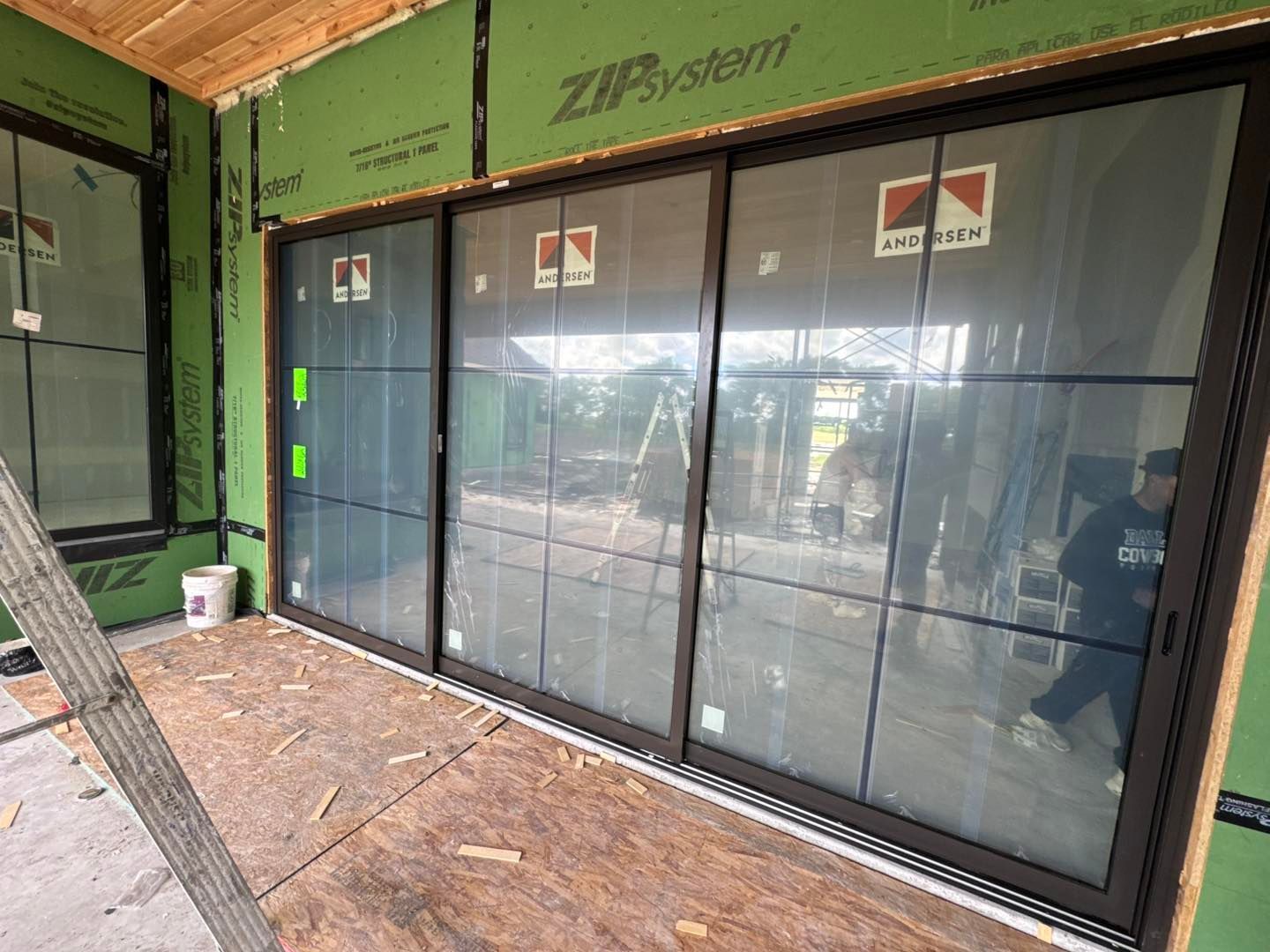 A sliding glass door is being installed in a house under construction.
