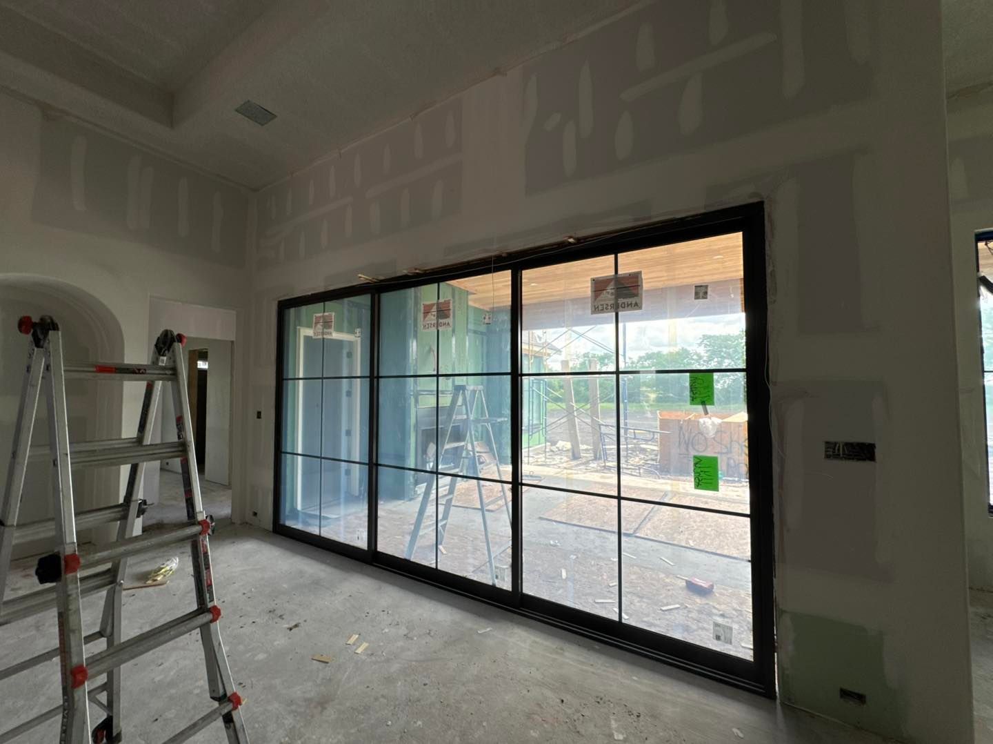 A room with a lot of windows and a ladder in it.