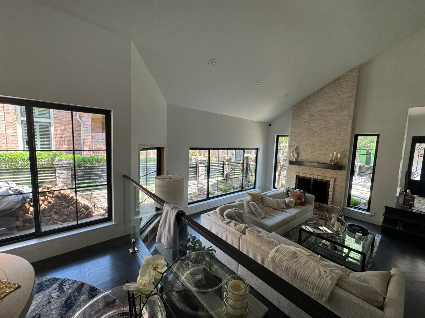 A living room with a couch , fireplace , and lots of windows.