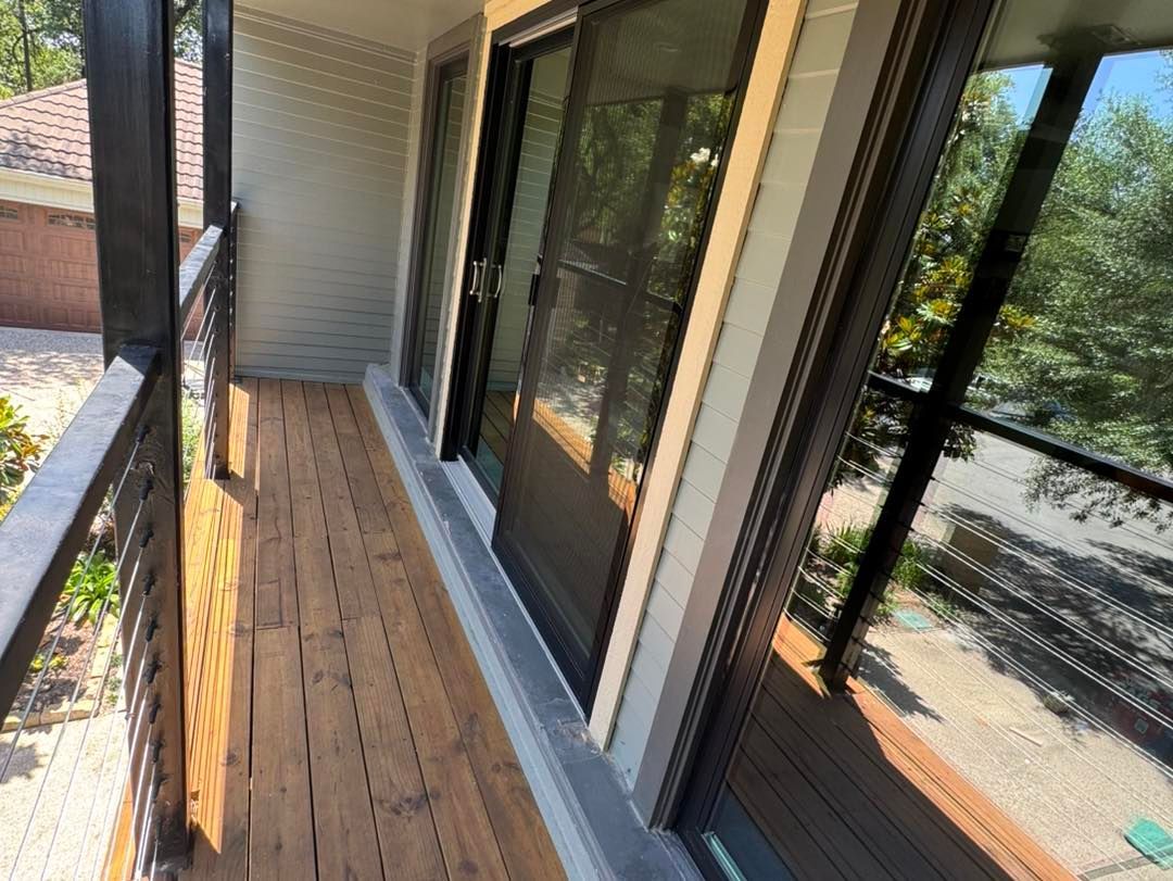 A balcony with sliding glass doors and a wooden deck.