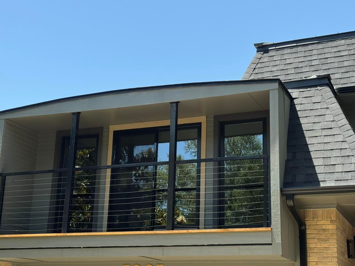 A house with a balcony and a gray roof
