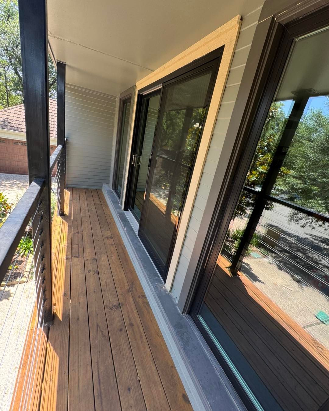 A balcony with sliding glass doors and a wooden deck.