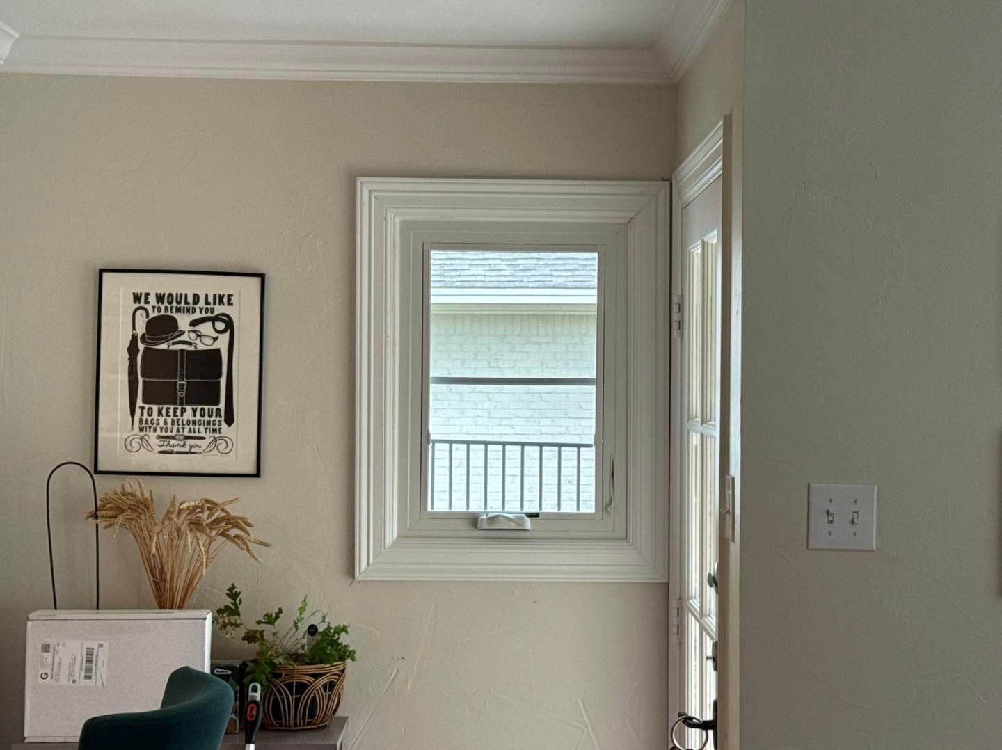 A living room with a picture on the wall and a window.