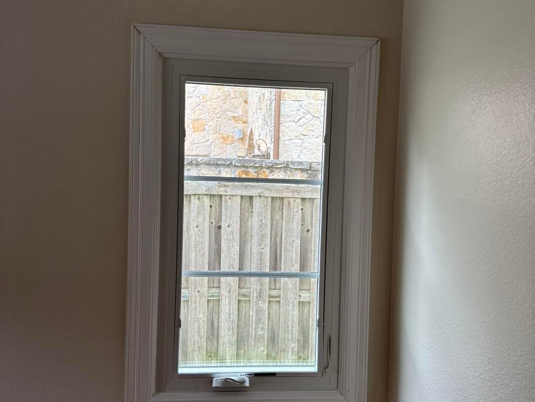 A window in a room with a wooden fence in the background.