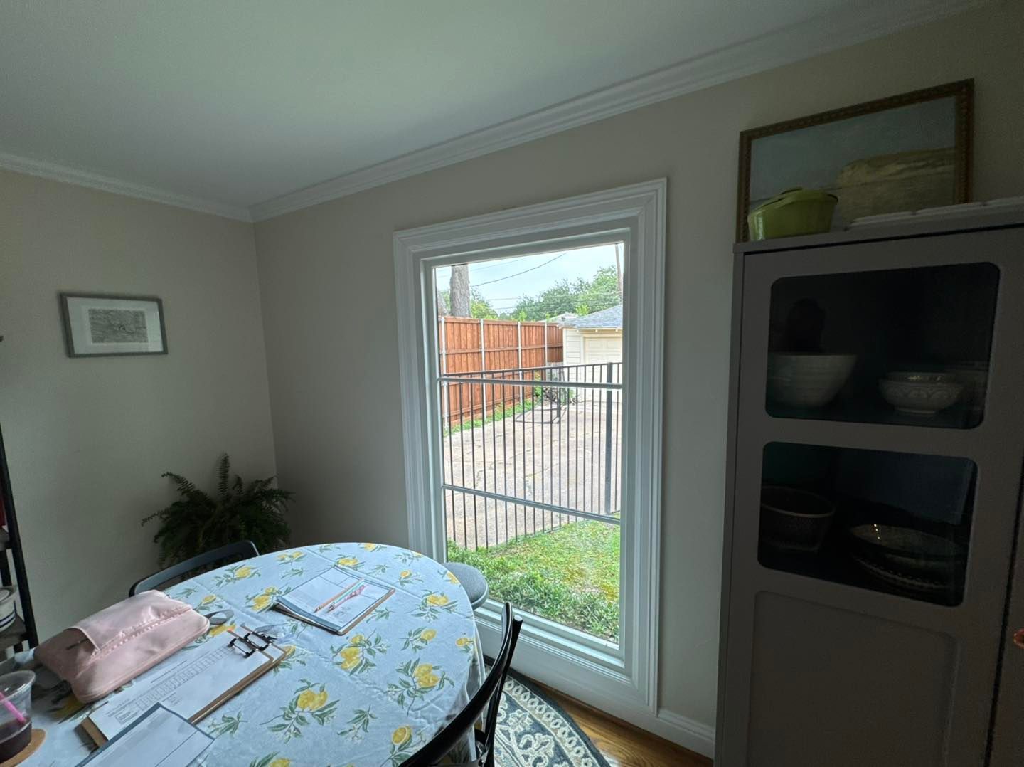 A dining room with a table and chairs and a large window.