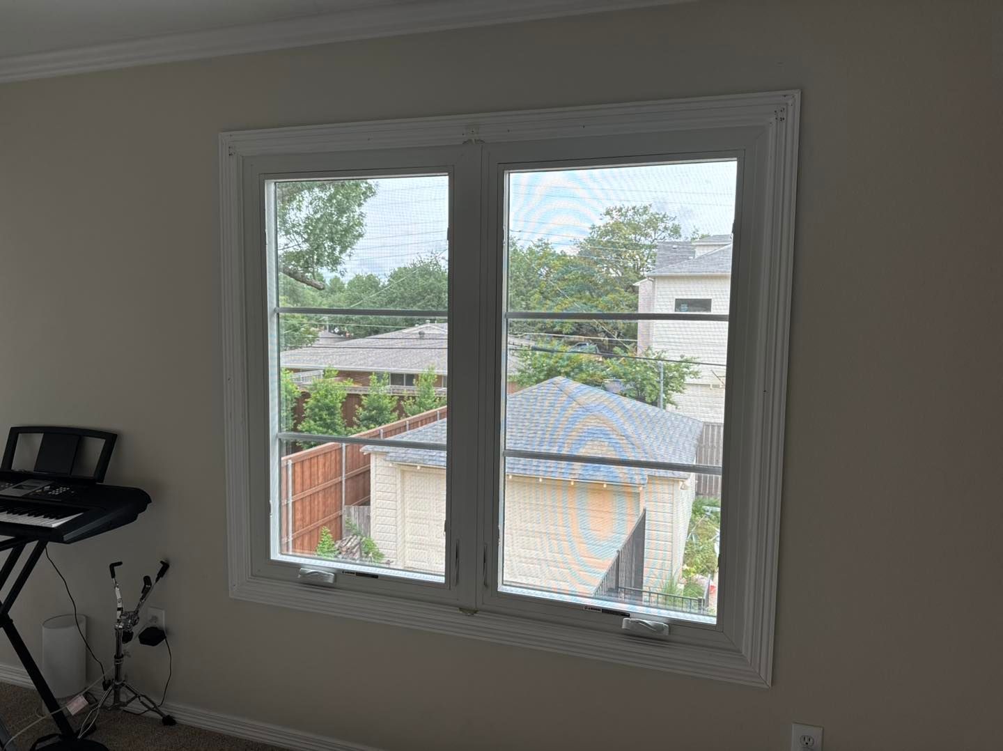 A room with two windows and a keyboard in it.