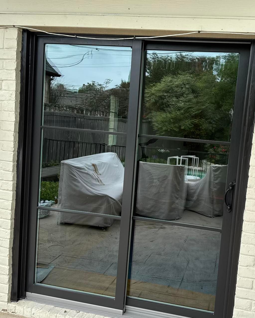 A sliding glass door with a reflection of a patio in it.