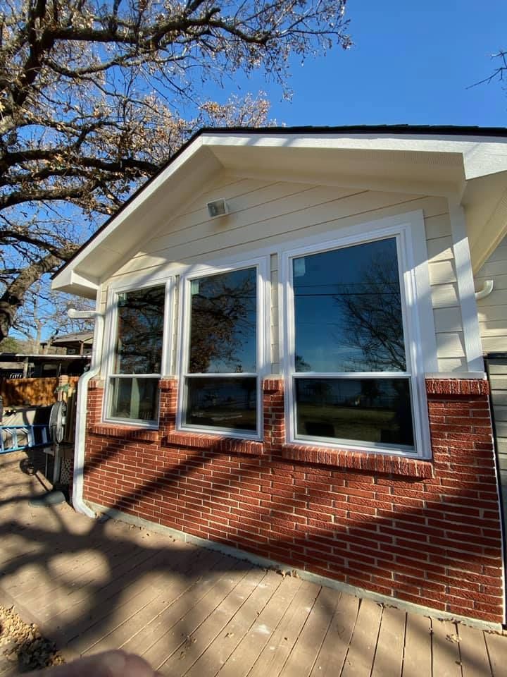 A house with a lot of windows and a brick wall.