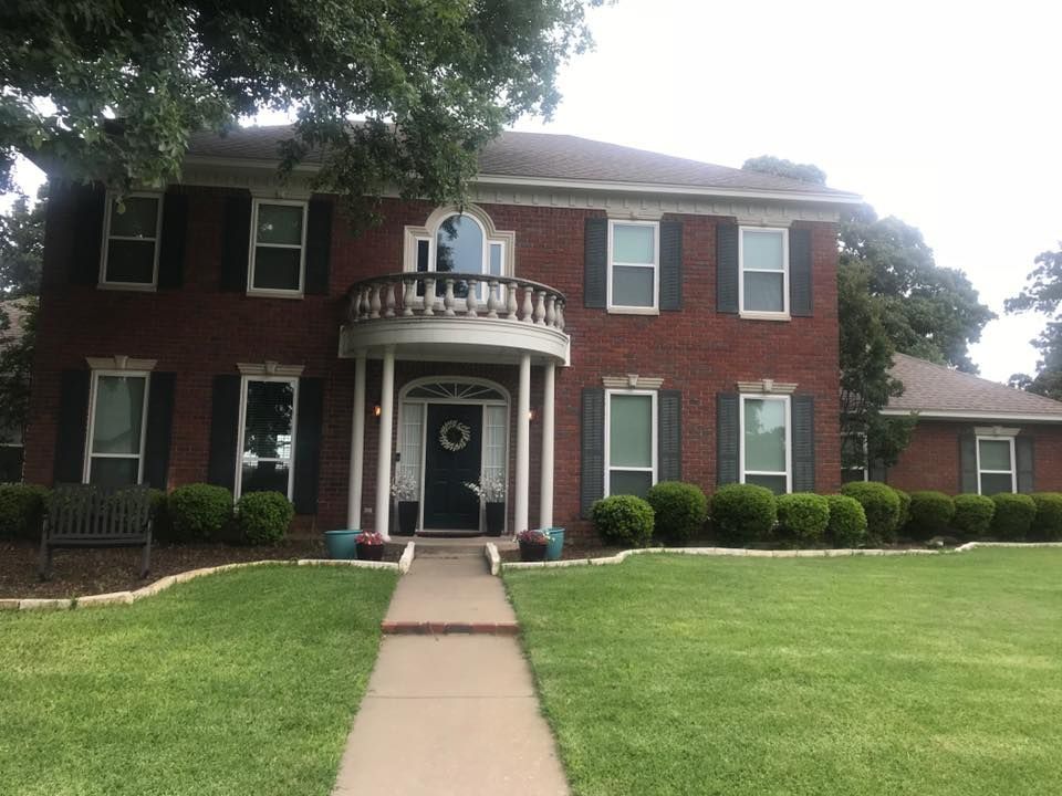 A large brick house with a walkway leading to it