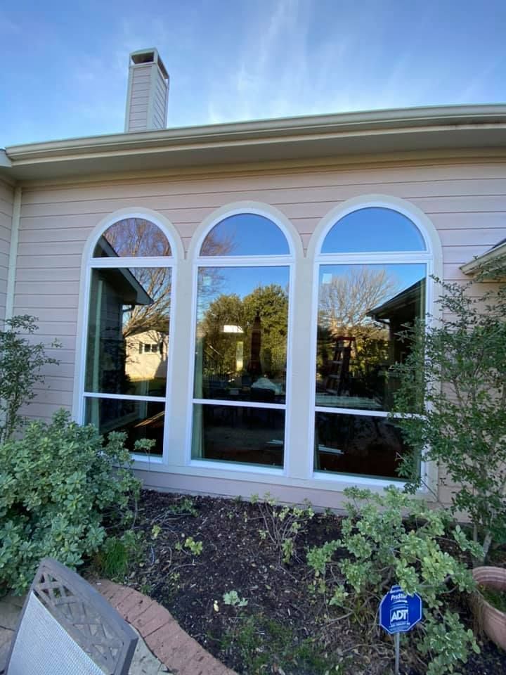 A house with three arched windows on the side of it.