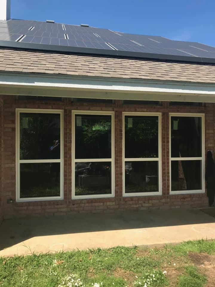 A house with a lot of windows and a solar panel on the roof.